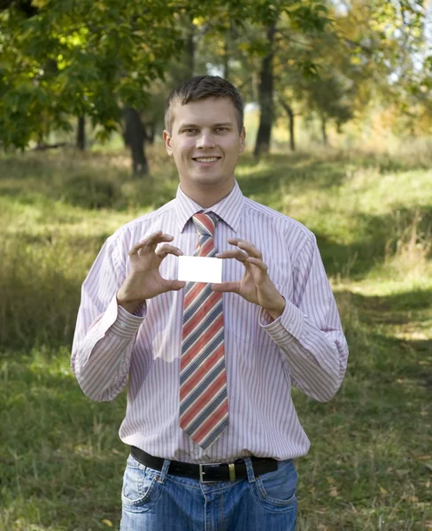 Young man handing a blank business card — Stock Photo, Image