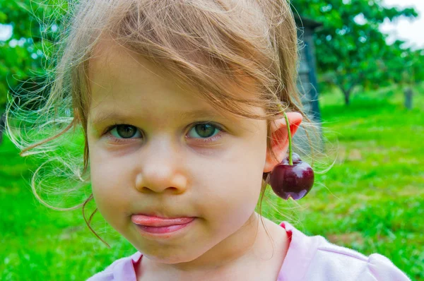 Ragazza con una dolce ciliegia sulle orecchie — Foto Stock