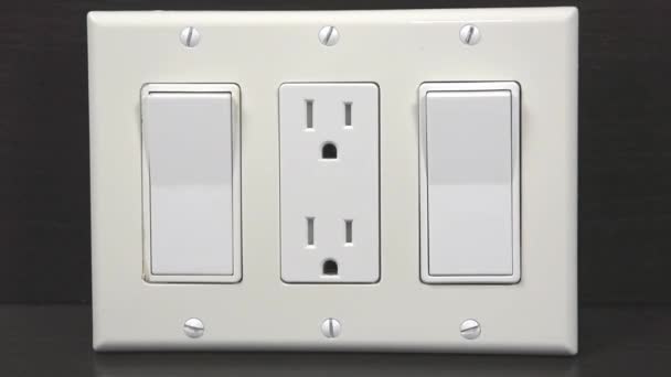 中间的两个开关和一个插座上覆盖着一个三重装饰的白色覆盖物 — 图库视频影像