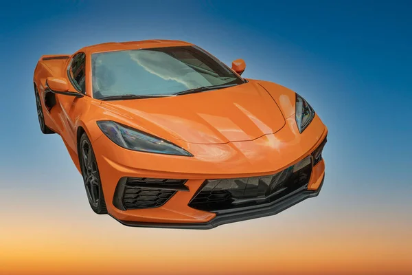Dark orange sports car against a blue sky