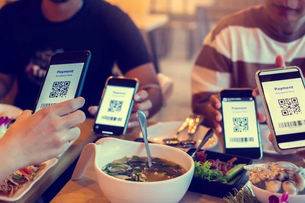 Selective focus to QR code tag and Barcode on smartphone in hands with blurry food and dessert in restaurant to accepted generate digital pay without money. QR code payment concept. Barcode Payment.