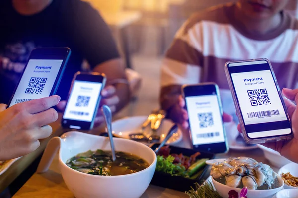 Selective focus to QR code tag and Barcode on smartphone in hands with blurry food and dessert in restaurant to accepted generate digital pay without money. QR code payment concept. Barcode Payment.