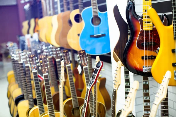 Selektywne Skupienie Się Gitarze Elektrycznej Rozmytymi Gitary Wiszą Salonie Muzycznym — Zdjęcie stockowe