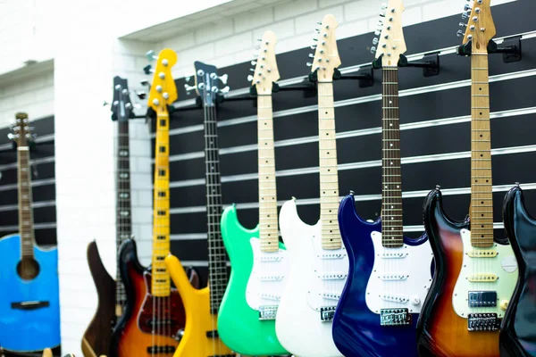 Selektywne Skupienie Się Gitarze Elektrycznej Rozmytymi Gitary Wiszą Salonie Muzycznym — Zdjęcie stockowe