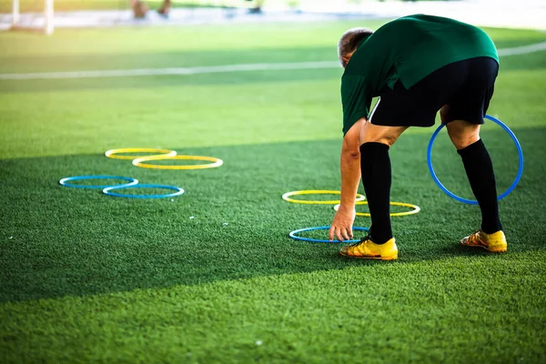 Coach is putting the marker ring for soccer training to run and jump. Football academy.