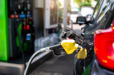 Benzin istasyonundaki bulanık yakıt kutusuyla eski kırmızı yakıt hortumuna seçici bir odak. Benzin istasyonunda yakıt doldur..