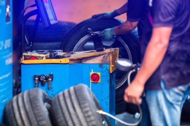 Otomobil garajındaki bulanık oto mekanik dengeli, tekerlek dengeleyici kontrol paneline seçici odaklanma. Araba Servisi.