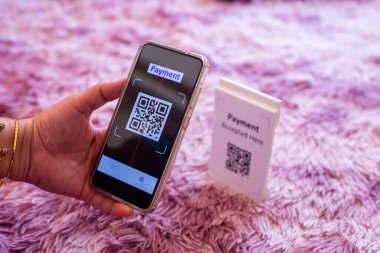 Beyaz arka planda QR kod ödemesini taramak için akıllı telefonu tutuyorum. Nakitsiz teknoloji ya da dijital ödeme kavramı.