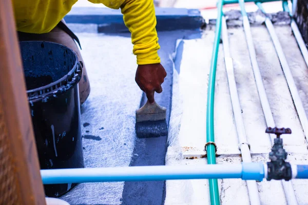 Painter is painting the gray flooring on fiber glass for waterproof, reinforcing net, Repairing waterproofing deck flooring.