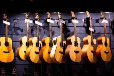 BANGKOK, THAILAND, 12-Aug-2022: Müzik dükkanında gitara, birçok gitara, pop rock sanatçısı şarkısı ve eğlence enstrümanına seçici odaklanma.