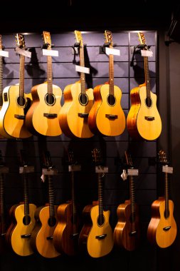 BANGKOK, THAILAND, 12-Aug-2022: Müzik dükkanında gitara, birçok gitara, pop rock sanatçısı şarkısı ve eğlence enstrümanına seçici odaklanma.