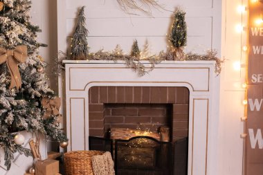 Evde hediyeleri olan taşralı bir şömine. Noel ağacı ve şöminesi dekore edilmiş bir oturma odası. Parlayan çelenkleri ve evde hediyeleri olan Noel ağacı. İskandinav İç Odası. 