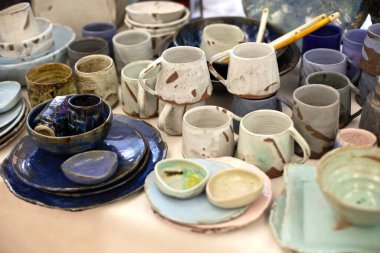 variety of plates, bowls, glasses and saucers from clay. Ecoceramic Handmade dishes  in wabi sabi style. Clay handcrafted dishes and ceramic cups. Collection of craft glazed tableware. Ecology concept