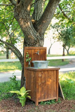 Hand outdoor washing facilities to prevent the spread of virus or disease. Vintage outdoor sink for rustic decor in yard. Handmade wooden Wash basin with soap in garden for hands cleaning in summer. 