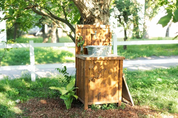 Handmade wooden Wash basin with soap in garden for hands cleaning in summer. Hand outdoor washing facilities to prevent the spread of virus or disease. Vintage outdoor sink for rustic decor in yard