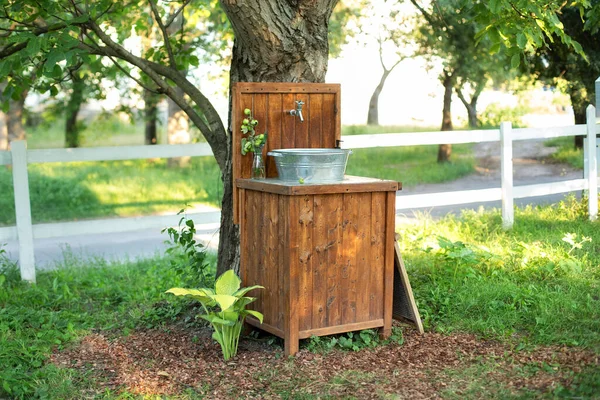 Handmade wooden Wash basin with soap in garden for hands cleaning in summer. Hand outdoor washing facilities to prevent the spread of virus or disease. Vintage outdoor sink for rustic decor in yard