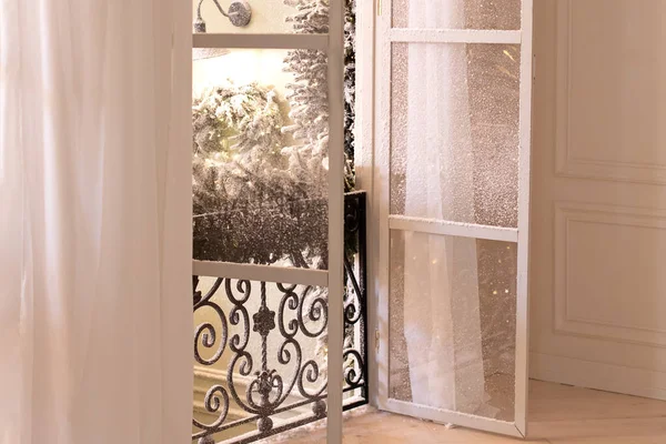 View from the light room on Balcony with wrought iron railings with open shutters and French doors. Home interior. Old mediterranean window and curtains. French doors with wrought-iron balconies.