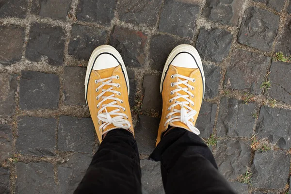 Close up Feet of man while walking commuting to work. Male in yellow sneakers being walking down the street. Confident man Feet Walking In City. Man Legs In in shoes Walking on sidewalk.