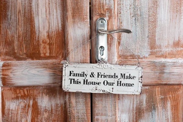 Brown wooden doors and hanging sign welcome. The part of wooden door with metal handle.