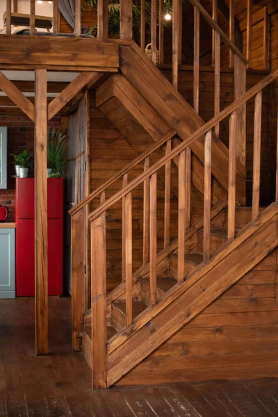 Wooden Stairway goes up. Country wooden house is spacious on two levels. Room with wooden stairway leading to second floor of modern flat. Modern staircase with wooden steps in flat.
