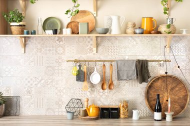 Seramik tabaklar, tabaklar, çatal bıçaklar ve ahşap raflardaki rahat dekorlar. Mutfak ahşap raflar, çeşitli seramik kavanozlar ve tencereler. Mutfakta rafları açın. Skandi mutfağının iç dekorasyonu çok şık.. 