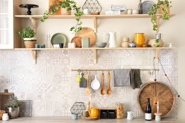 Seramik tabaklar, tabaklar, çatal bıçaklar ve ahşap raflardaki rahat dekorlar. Mutfak ahşap raflar, çeşitli seramik kavanozlar ve tencereler. Mutfakta rafları açın. Skandi mutfağının iç dekorasyonu çok şık.. 