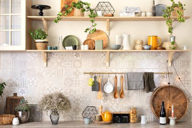 Skandi mutfağının iç dekorunu beğendim. Seramik tabaklar, tabaklar, çatal bıçaklar ve ahşap raflardaki rahat dekorlar. Mutfak ahşap raflar, çeşitli seramik kavanozlar ve tencereler. Mutfakta rafları açın.. 