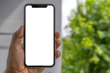 Erkek el ele tutuşması ve Bokeh özgeçmişli akıllı telefonu evde gösterme. Çevrimiçi konsept için boş ekran mobili. öğrenim ve iş pazarlaması için teknoloji iletişimi.