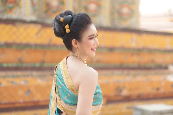 在一些重要的宗教节日 身穿泰国民族服装的亚洲妇女在寺庙里微笑着敬拜佛陀 为泰国人献上花环 — 图库照片