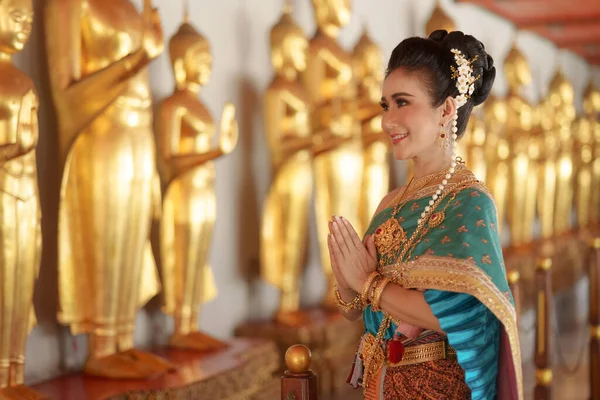 在一些重要的宗教节日 身穿泰国民族服装的亚洲妇女在寺庙里微笑着敬拜佛陀 为泰国人献上花环 — 图库照片