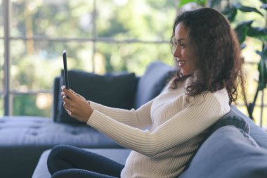 Young blogger african american woman live streaming in social media with tablet. Employees report with video conferencing. Female trainer is training online by network internet and application.