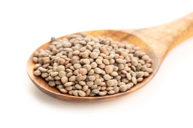Beyaz arka planda tahta kaşıkta mercimek. Mercek Aşçılık