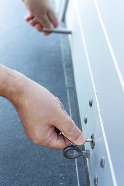 Bir mağazanın paten kepenk kapağını kapatan bir anahtarla El 'i kapat. Konsept kapanıyor