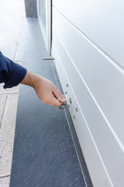 Bir dükkanın paten kepenk kapağını kapatan bir anahtarla. Konsept kapanıyor