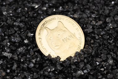 Siyah çakıllı arka planda Dogecoin madeni parası. Şifreleme para zinciri engelleyici para