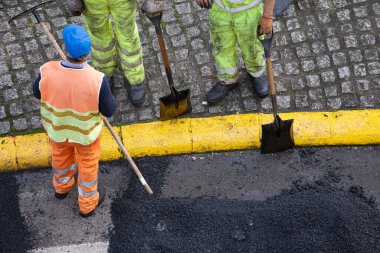 Şehir caddesinde Asphalting Road Work sırasında tanınmayan inşaat işçileri. Asfalt kaldırım. Yüksek açı görünümü