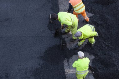 Şehir caddesinde Asphalting Road Work sırasında çalışanlar. Asfalt kaldırım. Yüksek açı. Boşluğu kopyala