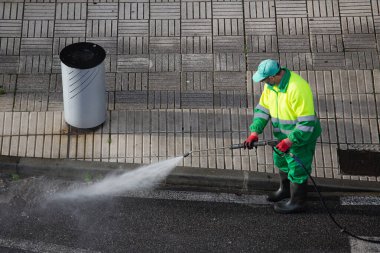 Galiçya, İspanya; 31 Aralık 2021: Yüksek basınçlı su jeti makinesiyle kaldırım temizleyicisi