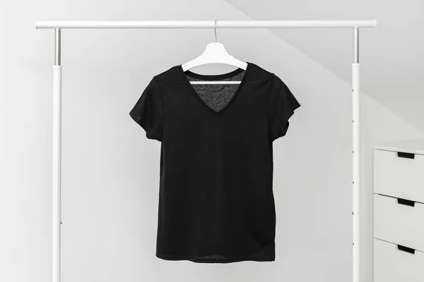 V neck t-shirt hanging on Clothing rack. Black color. Template, mock up