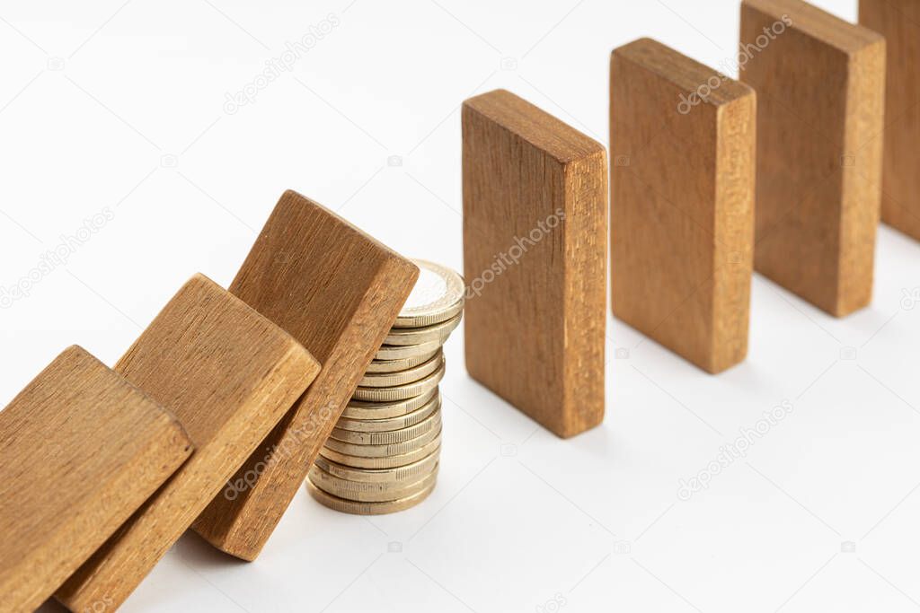 Pile of coins Stopping Falling wooden Dominoes effect. Money support or stimulus stop the financial crisis domino effect