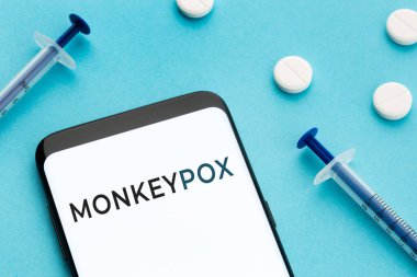 Mavi arka planda maymunçiçeği hapları ve şırıngaları olan Samrtphone