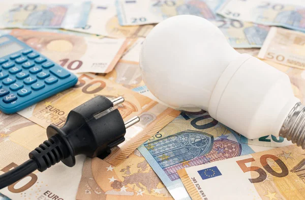 Energy prices cost on Europe concept. Light bulb, electrical plug, euro banknotes and calculator still life