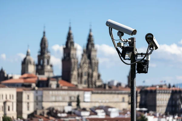 Scene of security cams on pole and Santiago de Compostela Cathedral blurred at background. Surveillance on Santiago de Compostela city concept