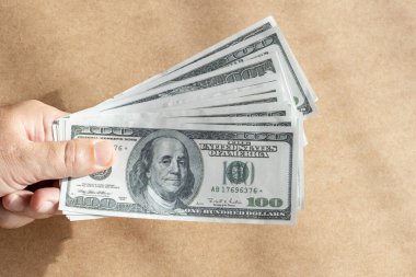 Bir grup dolarla el ele tutuşuyoruz. Yüz dolarlık banknot.