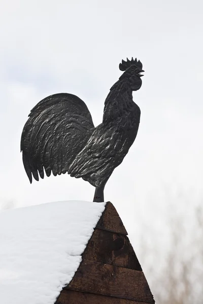 Metal rooster on the roof of a wooden — Stock Photo, Image