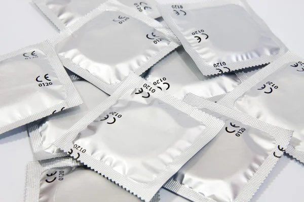 Birçok prezervatif ile gri arka plan — Stok fotoğraf