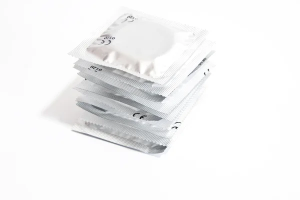 Стек презервативов на белом фоне — стоковое фото