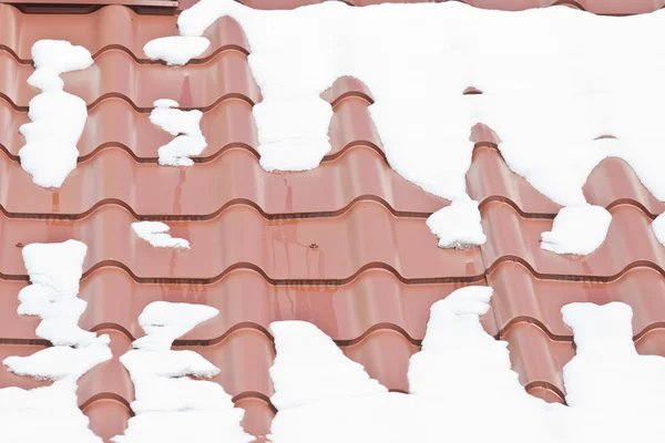 Melting snow on the roof with a metal roof — Stock Photo, Image