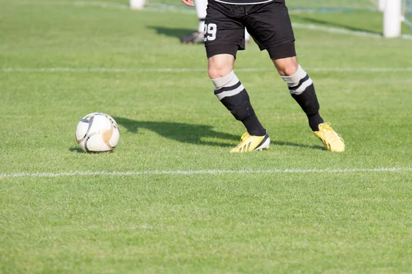 Jogador de futebol chuta a bola — Fotografia de Stock