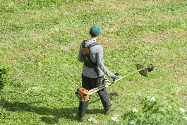 Werknemer het gras maaien met trimmer — Stockfoto